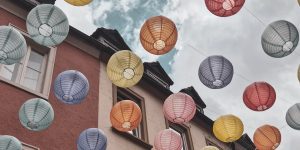 bunte Lampions, die zwischen Häusern in einer Gasse hängen